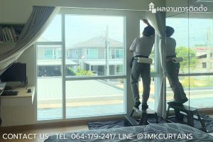 ช่างเทคนิคกำลังติดตั้งฟิล์มกรองแสงลดความร้อนบนหน้าต่างบานใหญ่ในห้องนอน