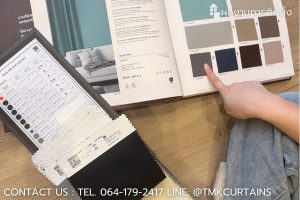 ลูกค้ากำลังเลือกเฉดสีผ้าม่านจากแคตตาล็อกตัวอย่างผ้าของ TMK Curtains สำหรับคอนโด Origin Plug & Play