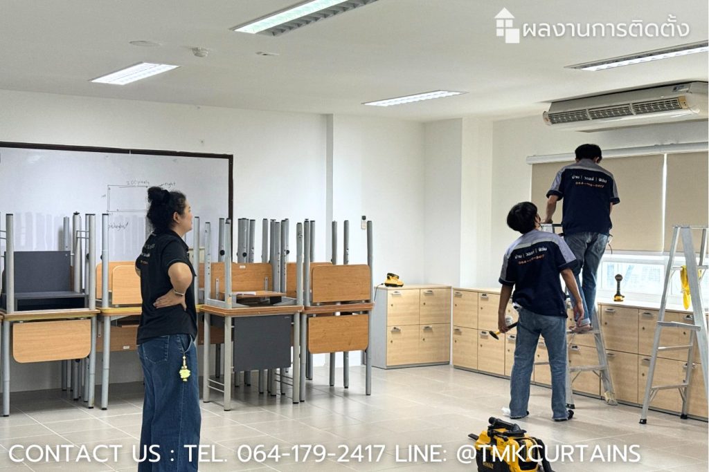 Installing premium blackout roller blinds in classroom - ช่างผู้ชำนาญการกำลังติดตั้งม่านม้วนทึบแสงในห้องเรียนช่วงปิดเทอม